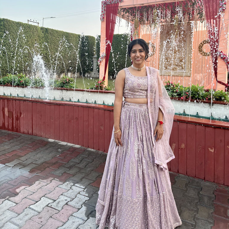 Purple sparkle lengha in front a fountain in india